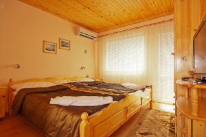 バルチクにあるVilla Karinaの木製の天井のベッドルーム1室(大型ベッド1台付)