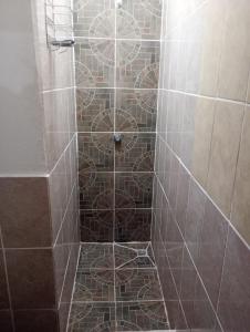 um chuveiro com piso em azulejo e uma porta em 59C hostel em Antigua Guatemala