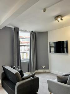 Comfortable flat in Stokes Croft في بريستول: غرفة معيشة مع أريكة وتلفزيون