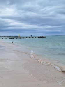 a sandy beach with a pier in the ocean at Apto estudio en Punta Cana, vista a la pisicina in Punta Cana