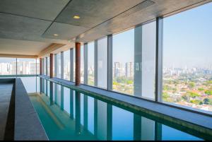 una piscina in un edificio con vista sulla città di Cyrela for you Ibirapuera Moema a San Paolo