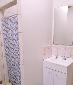 W łazience znajduje się umywalka i lustro. w obiekcie LE RIC HOUSING LTD w mieście Apia