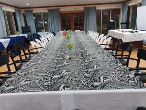 einen langen Tisch in einem Zimmer mit Stühlen in der Unterkunft LE RIC HOUSING LTD in Apia
