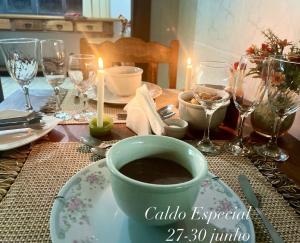 un tavolo con una tazza di caffè su un piatto di Pouso das Flores -350m Maria Fumaça a Tiradentes