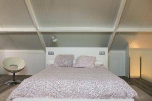 um quarto com uma cama grande e 2 almofadas em Villa Emérita em Vigo