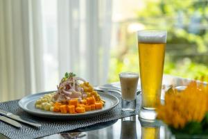 a table with a plate of food and a glass of beer at Habitación queen para 2 in Lima