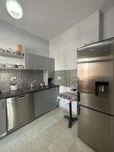 a kitchen with a stainless steel refrigerator and a table at Turdiu center apart in Tirana