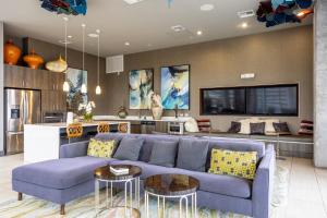 uma sala de estar com um sofá azul e uma televisão em Downtown 1br w gym wd pool nr Capitol ATX-83 em Austin