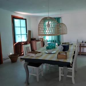 mesa de comedor con una lámpara de araña encima en La Delia en Villa Rumipal
