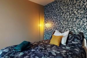 a bedroom with a bed with a black and white patterned wall at Proche Disney & Paris-2 min gare in Noisy-le-Grand