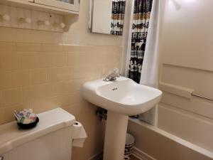 La salle de bains blanche est pourvue d'un lavabo et de toilettes. dans l'établissement Outpost Motel on the River, à Dolores