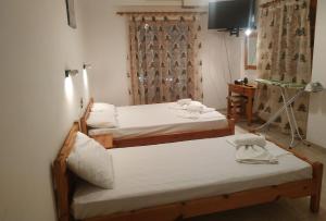 a room with two beds and a television in it at George Studios Stalida in Stalís