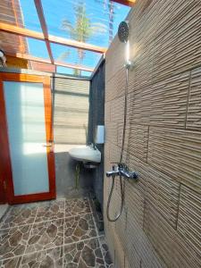 a bathroom with a shower and a sink at Maskot Penida Cottage in Nusa Penida