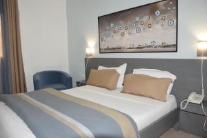 um quarto com uma cama grande e uma cadeira azul em Hotel Le Marly em Abidjan