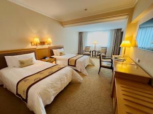 上海市にあるメイソン ホテルのベッド2台とデスクが備わるホテルルームです。