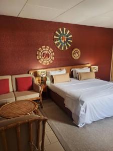 - une chambre avec un grand lit et un canapé dans l'établissement Hotel Le Marly, à Abidjan