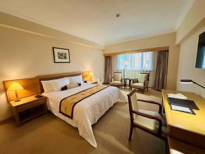 上海市にあるメイソン ホテルの大きなベッドとデスクが備わるホテルルームです。