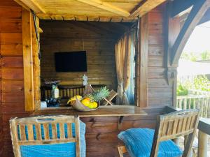 Habitación con mesa, 2 sillas y TV. en les gites du cocon en Cadet