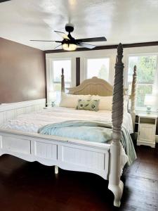 a bedroom with a white bed with a ceiling fan at The Vintage Daisy in Pocatello