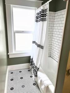 a bathroom with a shower curtain and a window at The Vintage Daisy in Pocatello