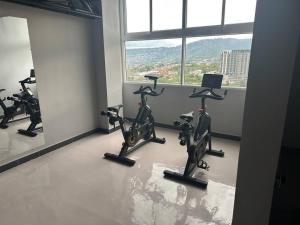 un gimnasio con bicicletas cardiovasculares en una habitación con ventana en Apartamento en Villa Firenze en Tegucigalpa
