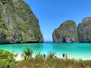 a group of people walking on the beach in halong bay at Best Point Condominium Cape Panwa in Phuket Town