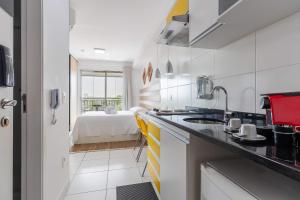 a kitchen with a sink and a bed in a room at Studio 7 minutos do Expo Center Norte in São Paulo