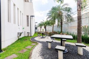 聖保羅的住宿－Studio 7 minutos do Expo Center Norte，庭院设有桌子和长椅,种有棕榈树