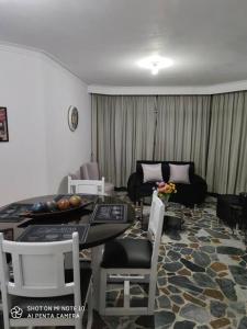 un salon avec une table, des chaises et un canapé dans l'établissement Comodo apartamento en Pereira, à Pereira