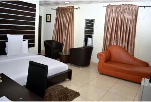 a bedroom with a bed and a couch and a chair at De Rigg Place - Alaka Estate, Surulere in Lagos