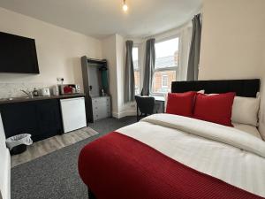a bedroom with a large bed with red pillows at Premier Nottingham Studios - Gawthorne in Nottingham