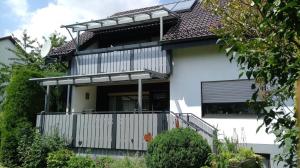 een wit huis met een balkon met een dak bij Ferienwohnung Irmgard in Deubach