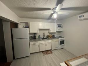 a kitchen with white appliances and a ceiling fan at View Haven Villa in Jolly Harbour