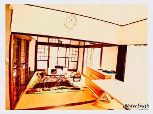 Habitación con cama y reloj en la pared en Guest House Nagasaki 1 御船蔵の我が家 1, en Nagasaki