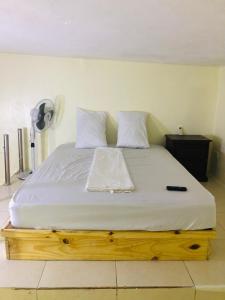 - un lit avec des draps et des oreillers blancs dans l'établissement HOTEL TREBOL, à Saint-Domingue
