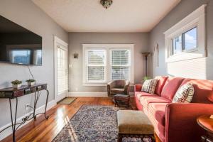 a living room with a red couch and some windows at Charming 2BR Getaway in New Albany