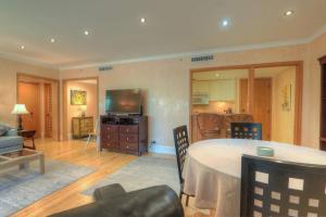 a living room with a table and a television at Perfect Condo Sleeps 8 Guests Florida in Palm Harbor