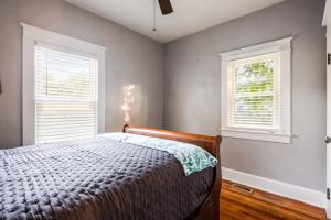 ein Schlafzimmer mit einem Bett und zwei Fenstern in der Unterkunft Charming 2BR Getaway in New Albany