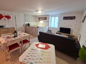 a living room with a couch and a table and a kitchen at Gîte Choloy-Ménillot, 2 pièces, 2 personnes - FR-1-584-119 in Choloy