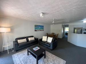 a living room with two couches and a table at Cascade Gardens Apartments in Gold Coast