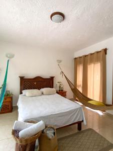 a bedroom with a bed and a hammock in it at Xkopek, Camping y Cabañas in Valladolid +29 photos