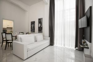 ローマにあるMorin 10 Rome Exclusive Suitesの白いリビングルーム(白いソファ、テーブル付)