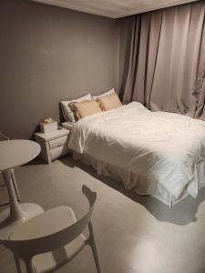 ein Schlafzimmer mit einem Bett, einem Tisch und einem Stuhl in der Unterkunft Stay Mido in Busan