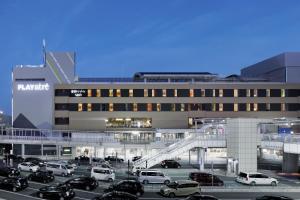 a parking lot with cars parked in front of a building at Hoshino Resort BEB5 Tsuchiura in Tsuchiura