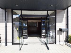 an entrance to a building with glass doors and parking meters at おやど 心 in Takayama