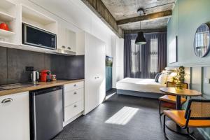 a kitchen with a bed and a table in a room at The Urban Newtown in Sydney