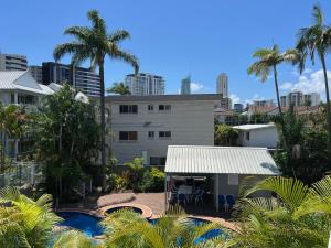 黃金海岸的住宿－瀑布花園公寓式酒店，享有带游泳池和棕榈树的建筑的景致