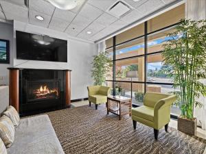 a living room with a fireplace and two chairs at Comfort Inn & Suites Downtown Tacoma in Tacoma