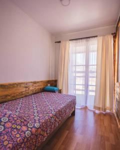1 dormitorio con cama y ventana grande en Cabaña el Mirador Caleuche., en Chañaral