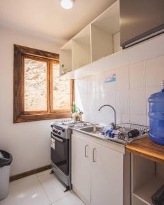 a kitchen with a sink and a stove top oven at Cabaña el Mirador Caleuche. in Ciudad de Chañaral